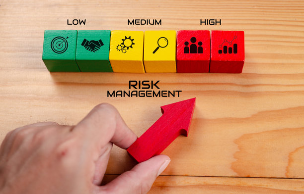 风险管理概念。风险评估等级指示器评级。商业评估测量。手指箭头指向绿色、黄色、红色木块，低到高图标，桌面背景，俯视图。图片下载