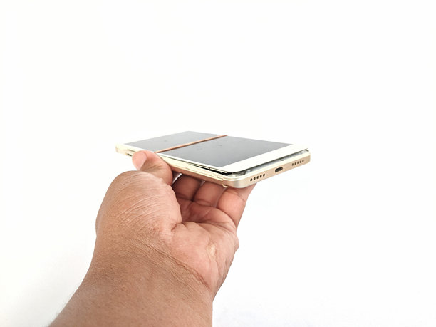 男性手握着一部损坏的安卓手机图片下载