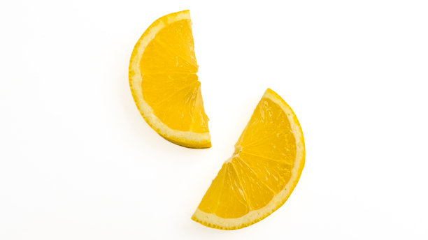 两个柠檬片半独立于白色背景，鲜嫩多汁的柠檬，剪贴画。高分辨率的柑橘类水果和切片柠檬照片。图片下载