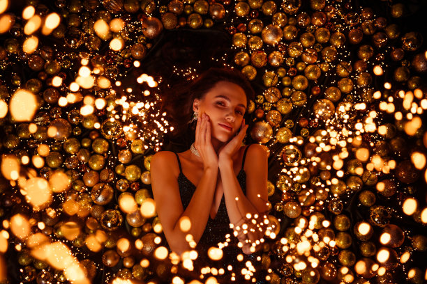 俯视图照片中，一位迷人的奢华女性与圣诞球和新年主题配饰相伴。图片下载