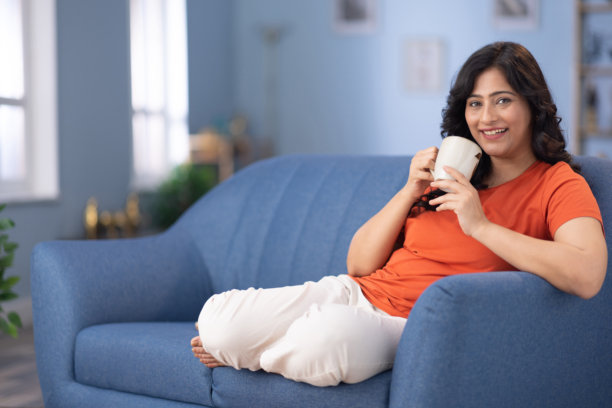 女人在家中沙发上喝咖啡的照片图片下载