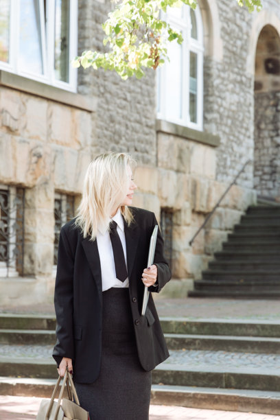 快乐的金发女性在温暖的天气里，手提包，穿着上衣，走在街上。高质量照片。图片下载