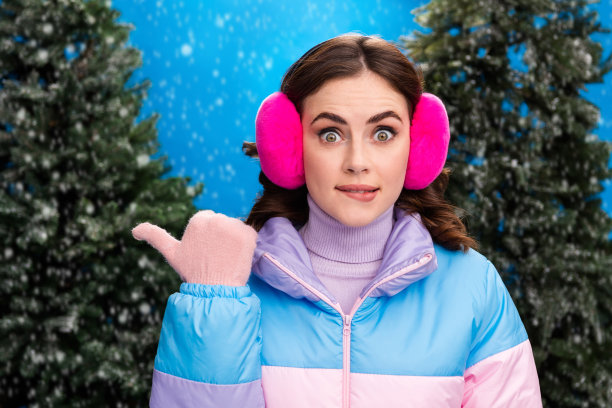 特写照片，漂亮可爱的女士在雪天的公园森林中，手掌送出空气之吻，享受户外魔幻时刻。图片下载