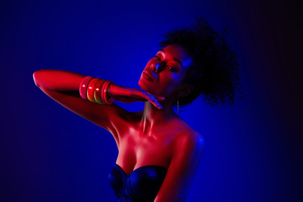 热情温柔的女孩在蓝色霓虹灯背景下的迪斯科夜总会中摆姿势的照片图片下载