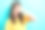 特写照片：年轻有趣的漂亮女孩穿着黄色T恤，遮住眼睛，张嘴露出兴奋、顽皮和震惊的反应，背景为水绿色。图片下载