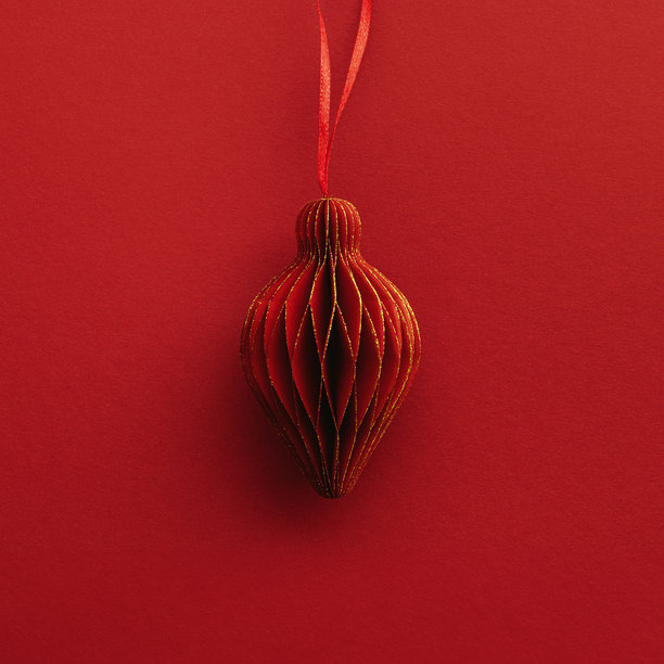 节日红色纸质圣诞装饰，悬挂的红色手电筒或灯笼，红色背景上的蜂窝状斯堪的纳维亚装饰，简约单色照片，温暖的节日气氛，俯视图，空白空间图片下载