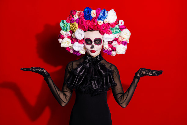 死去的卡特里娜新娘面孔的照片，展示传统节日文化，双手张开，宗教、死亡、工艺品，商店里的花卉玫瑰头带，黑色服装，背景为紫色。图片下载