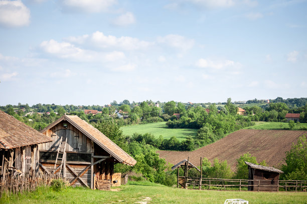 科斯迈的乡村风景中，谷仓和马厩的全景。照片突显了塞尔维亚农业和传统农场建筑的元素。图片下载