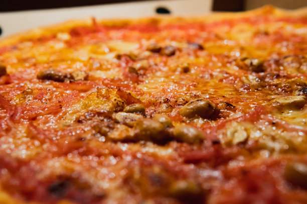 美味瑞典披萨的特写照片，上面放有火腿、奶酪和花生。图片下载