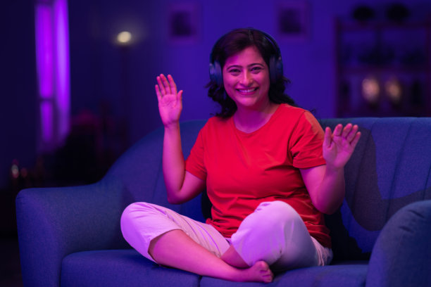 美丽的女人戴着耳机听音乐，举起双手唱歌跳舞的照片图片下载