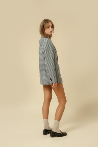 一系列女性穿着经典的斑马纹西装外套、袜子和黑色皮革便鞋的工作室照片图片下载