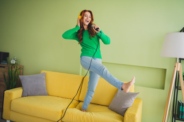 漂亮年轻女性在室内公寓的绿色环境中跳舞唱歌，享受周末时光的全身照片图片下载