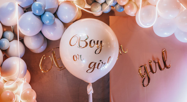 气球上写着“男孩还是女孩？”的性别揭晓派对。婴儿洗礼照片区图片下载
