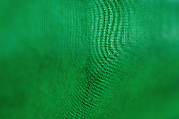 一张绿色织物的特写照片，展现出鲜艳的纹理和细节，营造出充满活力和动感的感觉，非常适合设计使用。图片下载