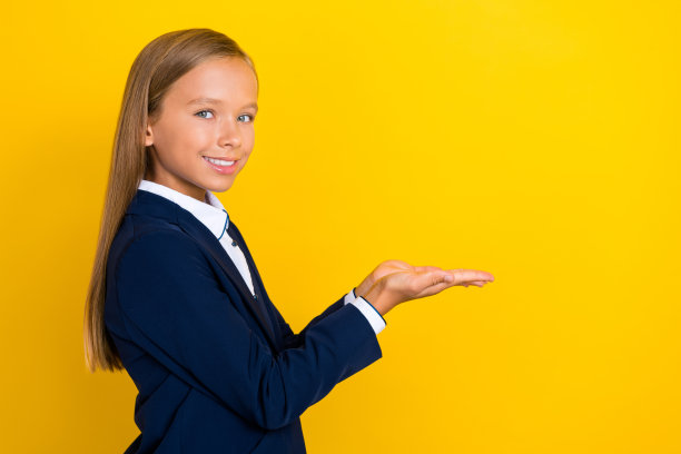 侧面肖像照片，漂亮积极的女孩手臂托着展示酷炫产品，空白空间，背景为黄色。图片下载