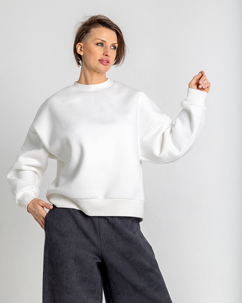 模特外貌的美丽女性肖像。女孩穿着白色卫衣和黑色裤子，背景为灰色。时尚妆容的漂亮女性在摄影棚中摆姿势。竖版照片图片下载