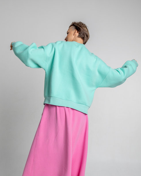 美丽的模特外貌女孩。穿着薄荷色卫衣和粉色裙子的美丽女性肖像。竖版照片图片下载