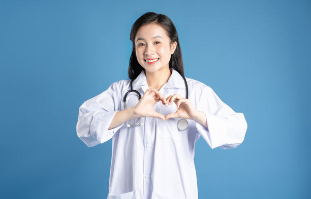 亚洲女性医生在蓝色背景前摆姿势的图片图片下载