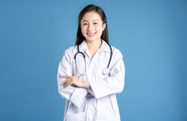 亚洲女性医生在蓝色背景前摆姿势的图片图片下载