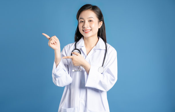 亚洲女性医生在蓝色背景前摆姿势的图片图片下载