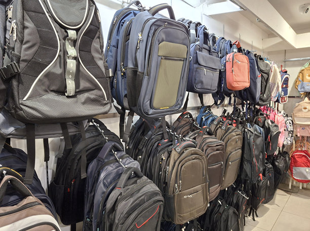 在一家背包店展示的各种背包，侧面拍摄的背包悬挂在店内的照片图片下载