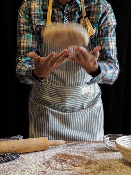 面包师制作手工面包。烘焙工具。黑色背景。黑白照片。图片下载