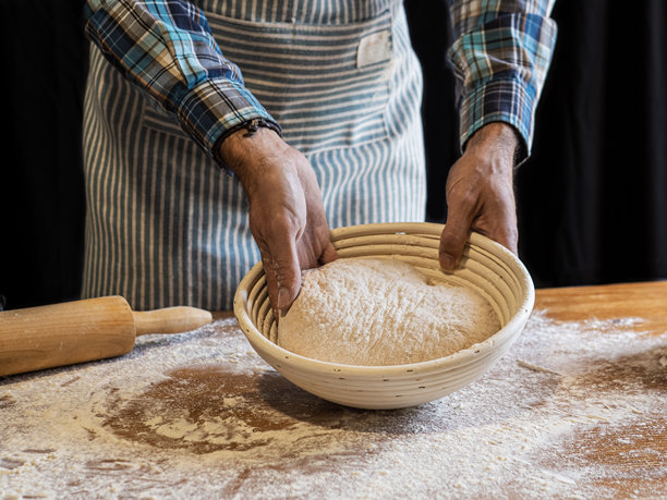 面包师制作手工面包。烘焙工具。黑色背景。黑白照片。图片下载