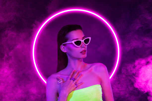 严肃女孩模特的合成照片拼贴，穿着时尚太阳镜，配有霓虹紫色圆圈和雾气，华丽的戒指，背景为涂鸦风格。图片下载