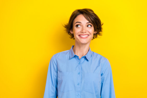 年轻兴奋的积极女性企业主特写照片，面带灿烂笑容，目光专注，背景为黄色，空白处可填充信息。图片下载