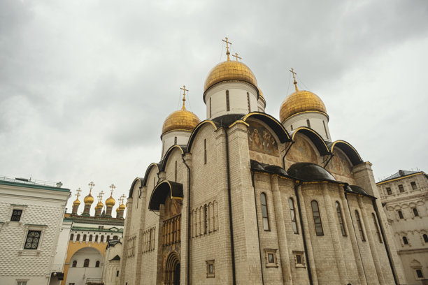 克里姆林宫内金色圆顶教堂的照片，展示了复杂的俄罗斯东正教建筑，背景是阴云密布的天空。图片下载