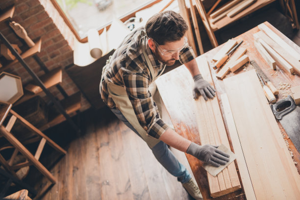 专注于在车库桌子上用木板工作的建筑工人顶部照片图片下载