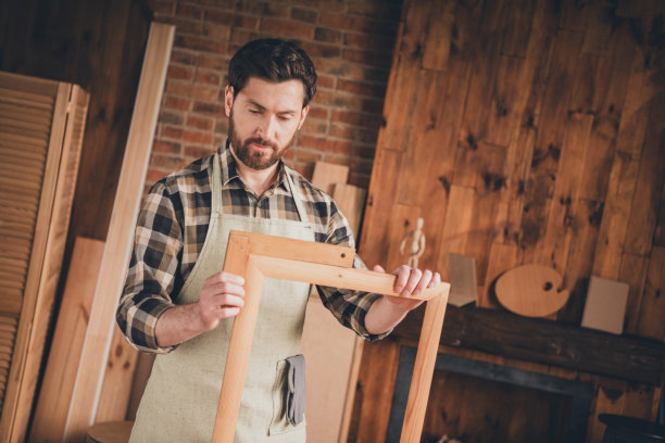 专业工匠在室内车库中手持边框测量工具的照片图片下载