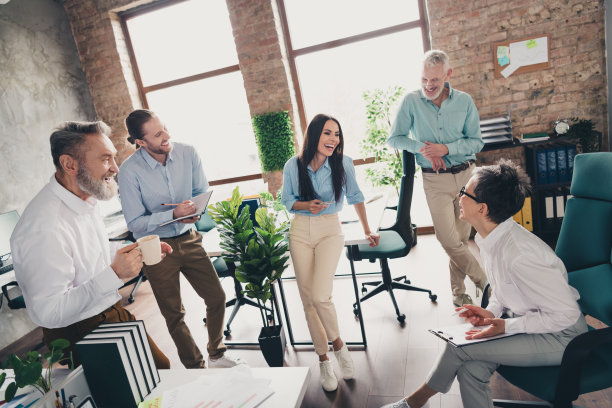 团队成员在舒适的办公室阁楼内一起工作、欢笑、交流，享受愉快的时光的全身照片图片下载