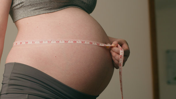 孕妇用卷尺测量肚子，孕期照片图片下载