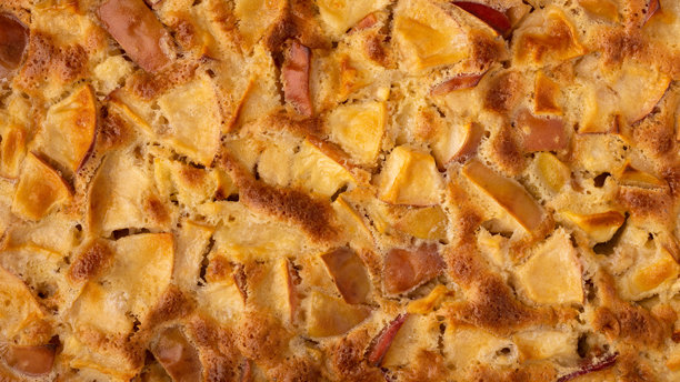 新鲜出炉的苹果夏洛特蛋糕完全填满画面。俯视图。16x9格式的背景照片。图片下载