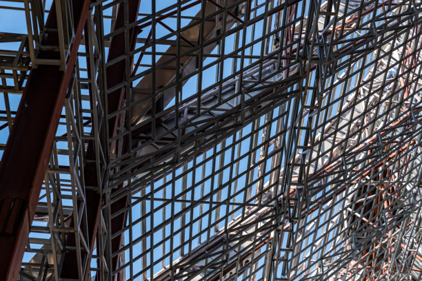 工地上正在建设的巨大钢屋顶框架结构细节的仰视角度照片。图片下载
