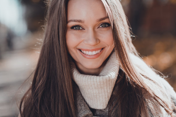 在街道上穿着外套毛衣的搞笑长棕发女士的裁剪照片图片下载