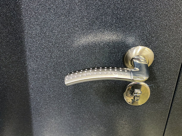 这张图片展示了一个现代黑色门把手的特写，强调其独特的设计、质感和复杂的五金细节，营造出引人注目的视觉效果。图片下载