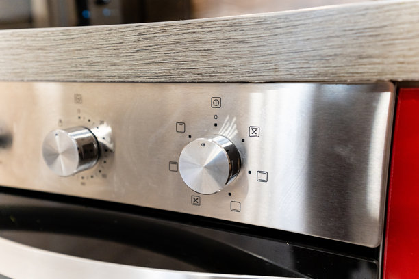 这张图片展示了不锈钢烤箱控制面板的细致特写，突显其流线型设计和现代功能，非常适合任何现代厨房。图片下载