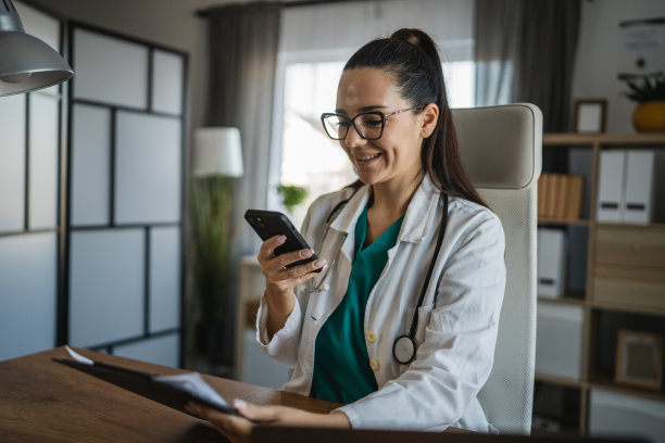 女医生在诊所办公室用手机拍摄夹板的照片图片下载