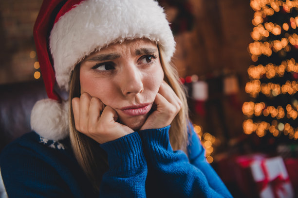 漂亮年轻女孩的特写照片，双手托着脸颊，思考中，穿着毛衣，圣诞假期，室内公寓。图片下载