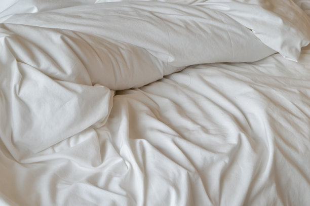 这张图片展示了一张白色床单的特写，皱褶且有纹理。图片下载