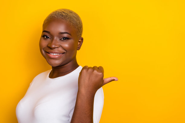 迷人的女士特写侧脸照片，穿着时尚的白色服装，手臂和手的拇指在黄色背景上留有空白空间。图片下载