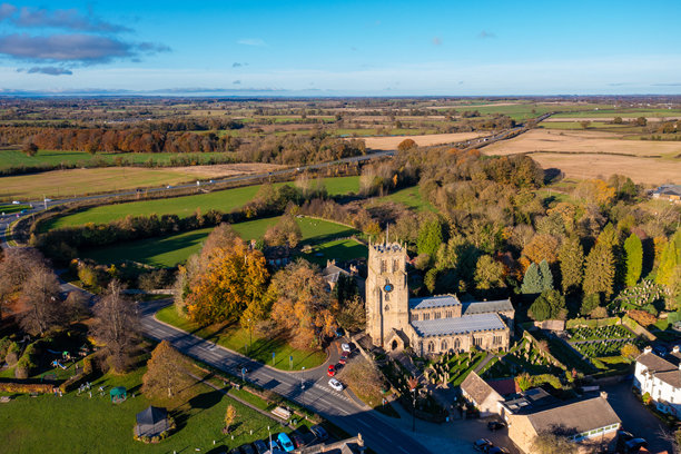 贝代尔美丽小镇的航拍照片，位于北约克郡的汉布尔顿旧区，展示了美丽的小镇、教堂和高速公路的秋季景色。图片下载