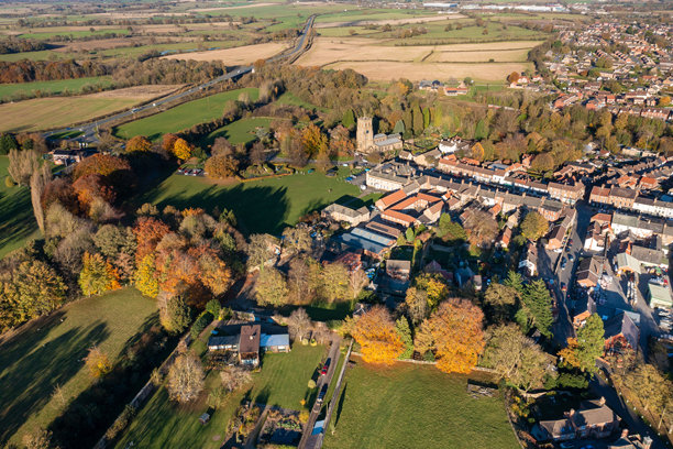 贝代尔美丽小镇的航拍照片，位于北约克郡的汉布尔顿旧区，展示了美丽的小镇、教堂和高速公路的秋季景色。图片下载