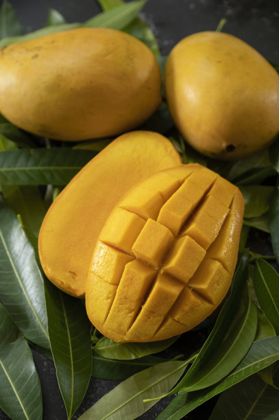 切片的芒果果实，配有绿色叶子，清晰的自然背景特写照片 - 库存照片图片下载