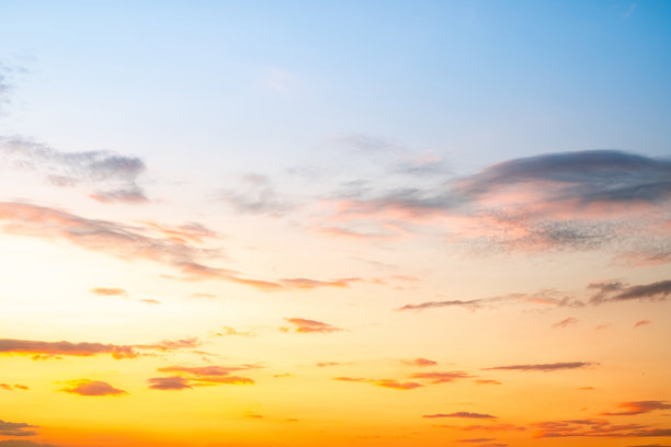 像明亮的金色和蓝色天空。日出被各种形状的云彩装饰，黄昏，暮光，大尺寸，高分辨率风景照片图片下载