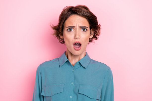 特写照片：年轻漂亮可爱的女性张嘴无言，表情搞笑、兴奋、疯狂，反应不快，背景为粉色。图片下载