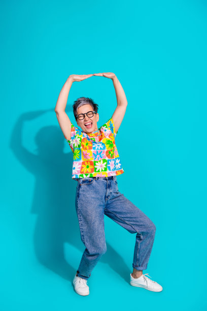 全身竖版照片，优雅的老年女性在青绿色背景上手持空白广告牌。图片下载