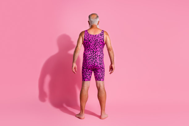 老年男子背影照片，穿着豹纹泳衣，背景为柔和的粉色。图片下载